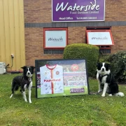 Waterside Food Services Limited - Directors pets in front of sponsorship frame for Walsall Football Club